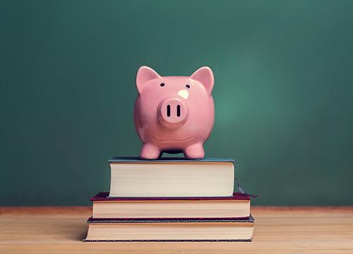 Piggy bank on top of school books